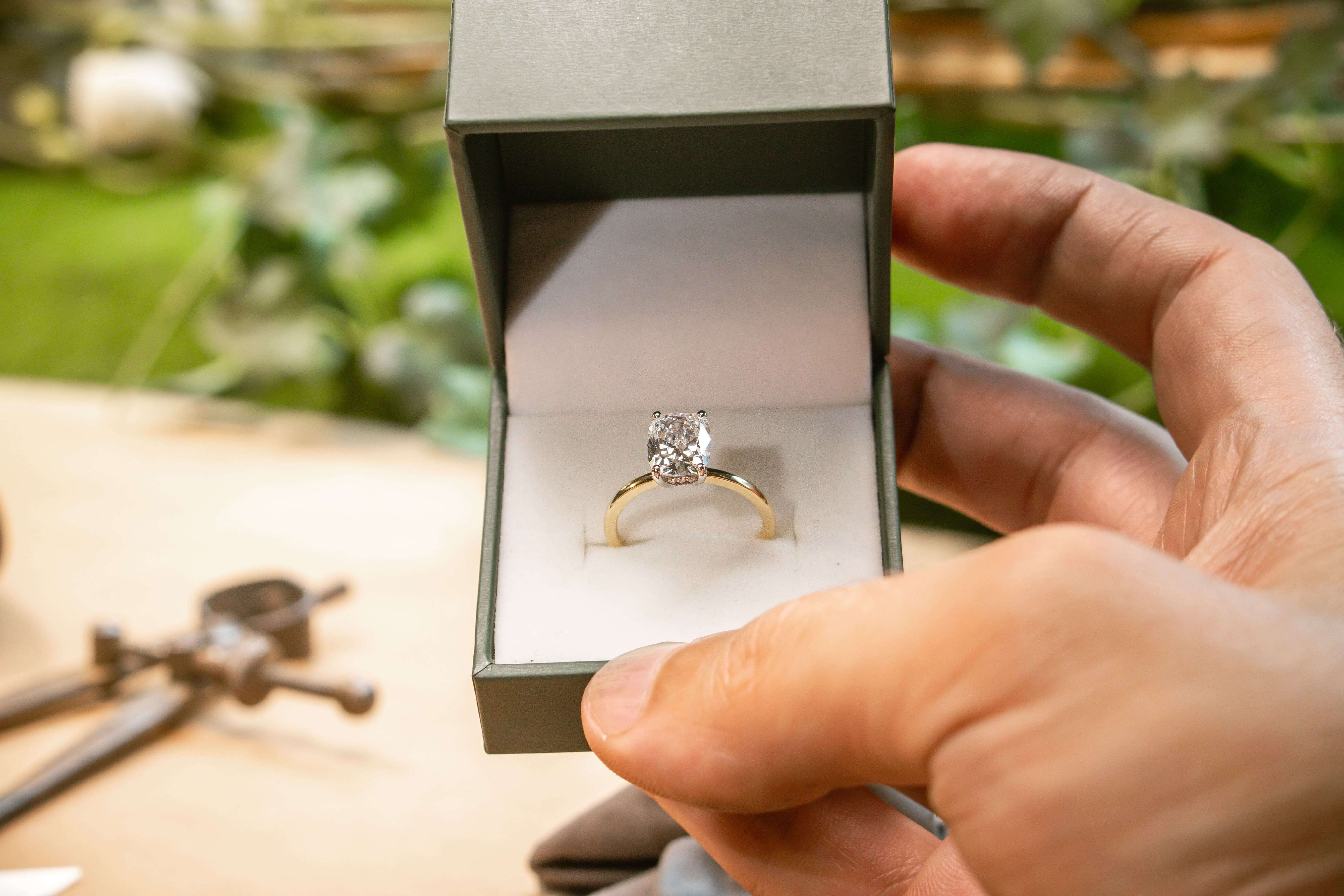 Design sketches and finished ready-to-wear rings on a bench