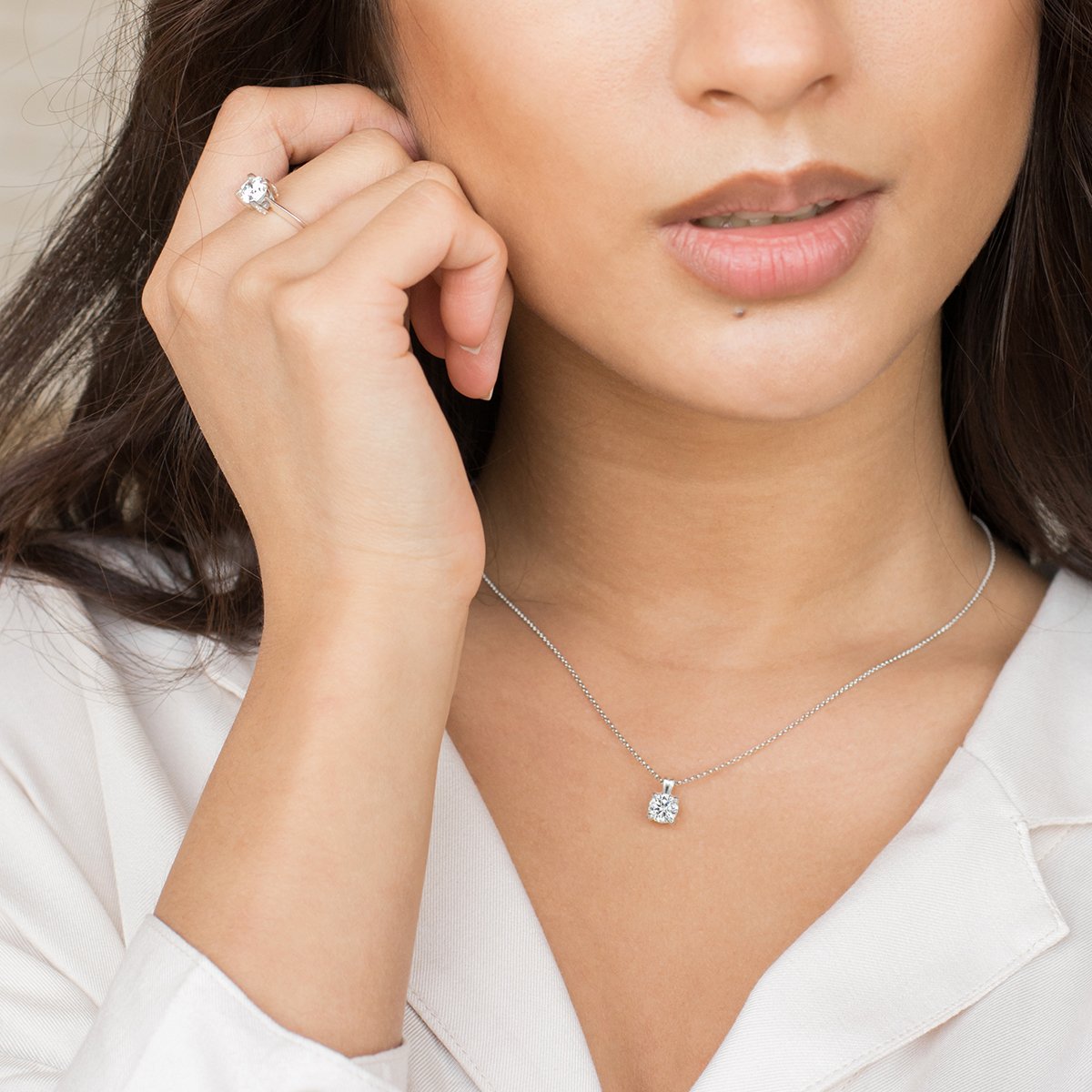 a woman in a white dress talking on a cell phone